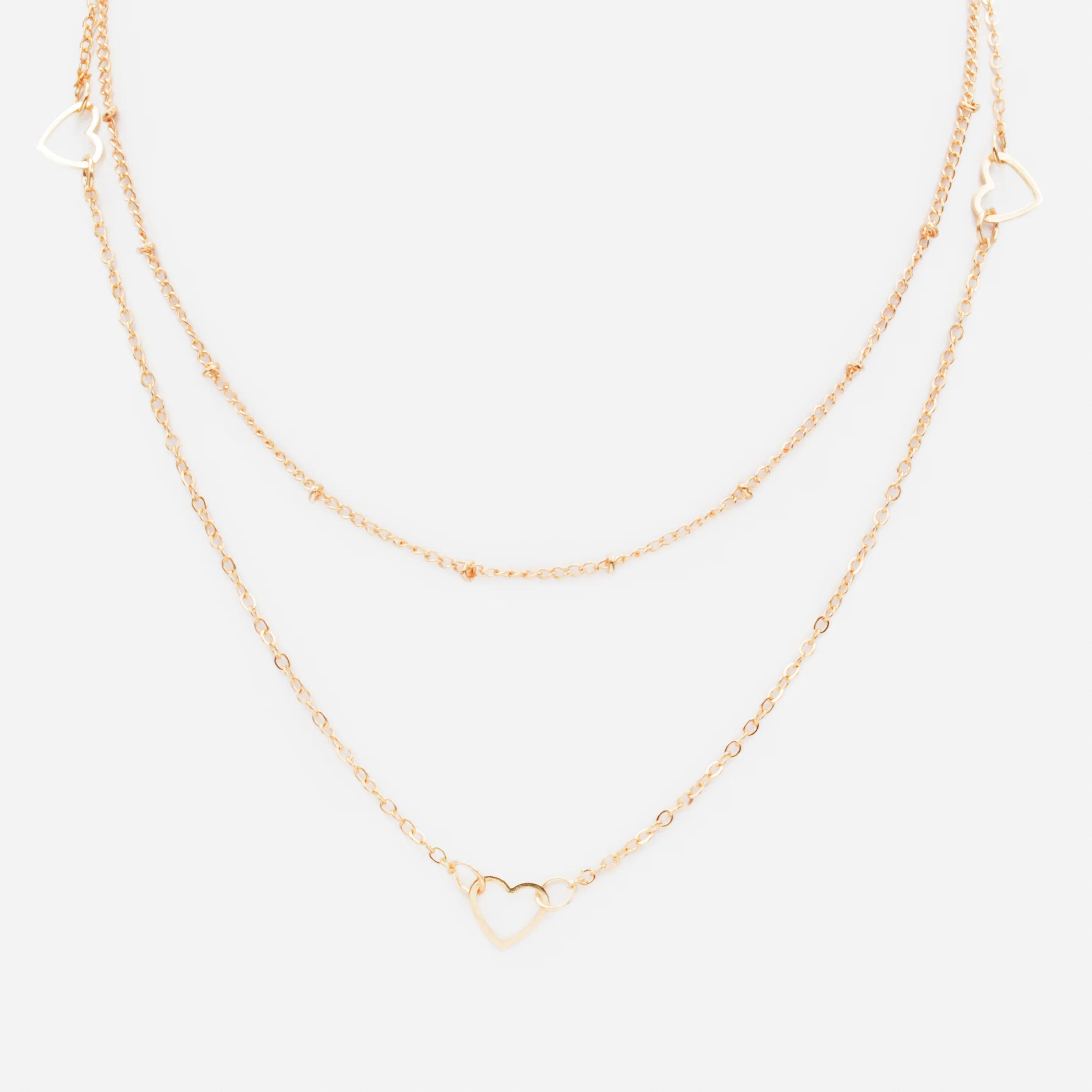 Collier doré double chaîne avec trio de coeurs