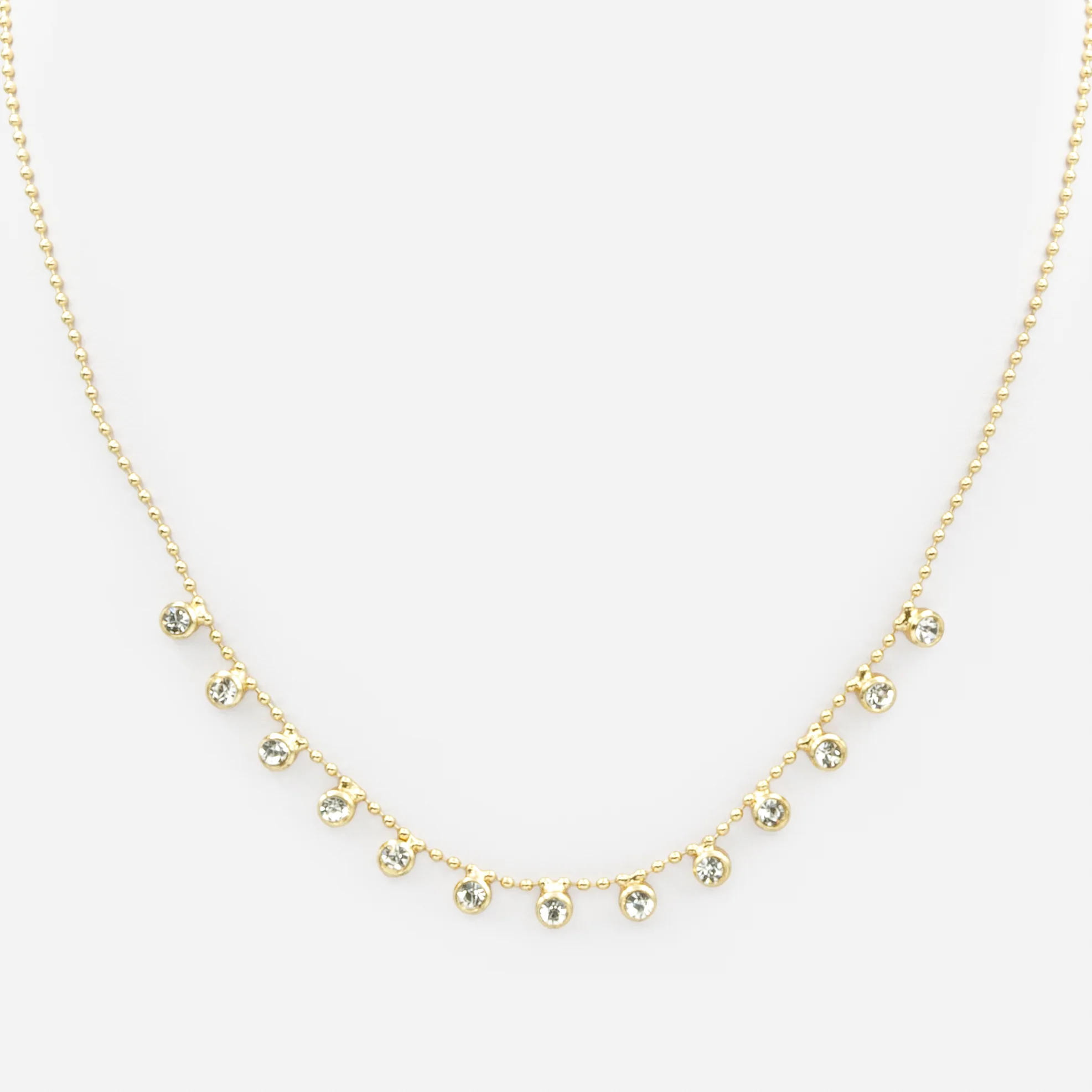 Collier de fines billes dorées avec breloques de zircons cubiques