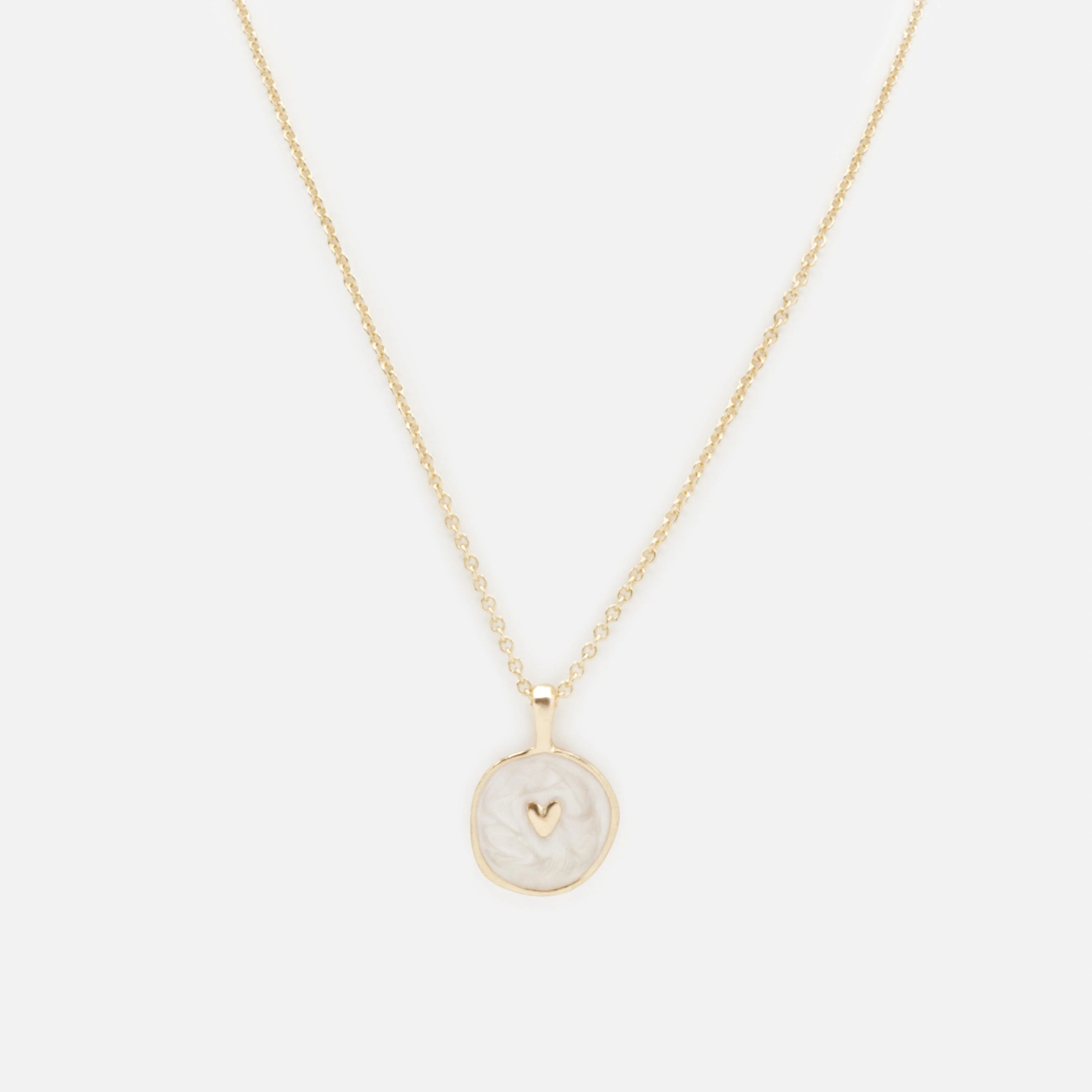 Collier doré petit cœur sur fond blanc nacré